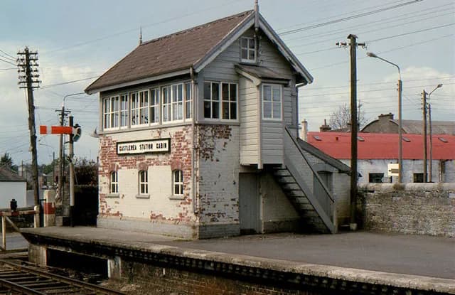 The signal cabin at Castlerea station: brick below, timber boarding and glazing above, reached by an external stair.